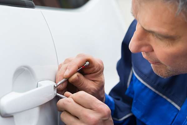 Hand Holding Lockpicker To Open Car Door Locksmith opening locked car door